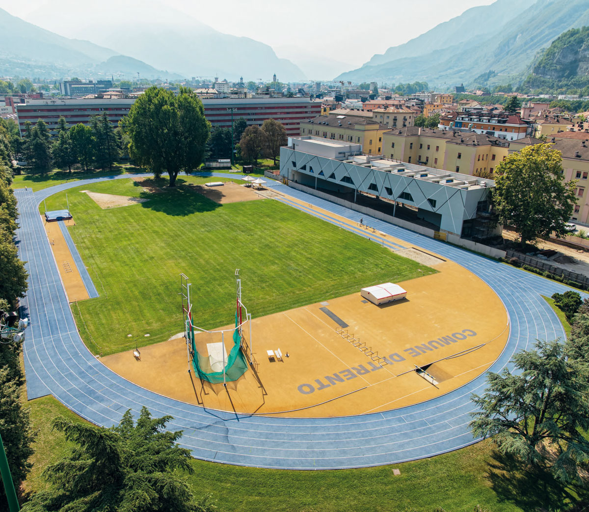 Pista di atletica del campo scuola Covi e Postal di Trento, con vista dell'edificio indoor.